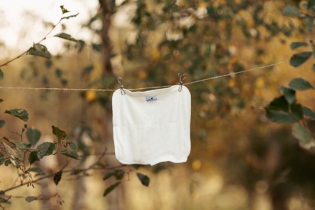 WeeCare Nyfødt bambusindlæg hænger på en tørresnor i naturen.