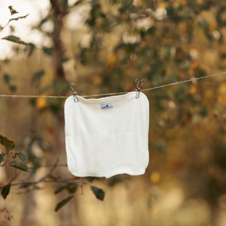 WeeCare Nyfødt bambusindlæg hænger på en tørresnor i naturen.